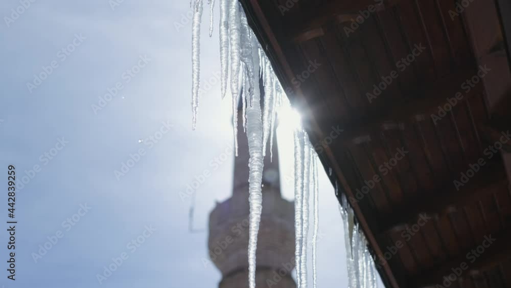 Beautiful dripping icicles on a warm bright sunny day. Melting Icicles. the mosque minaret visible in the background. 4K. Beautiful dripping icicles on a warm bright sunny day. Melting Icicles. the mosque minaret visible in the background. 4K.