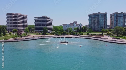 Drone video circling a fountain in the water beside a park photo