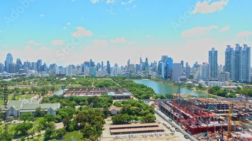 Queen Sirikit National Convention Centre construction site near Benjakitti Park and Lake, Millenium Residence Apartment, CTI Tower, Ocean Tower in Bangkok, Thailand on Sunny day time-lapse
 photo