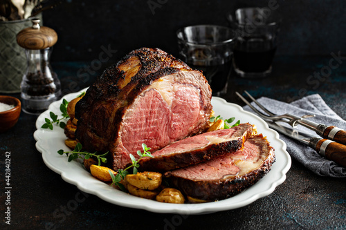 Fotografia Prime rib roast sliced for celebration dinner