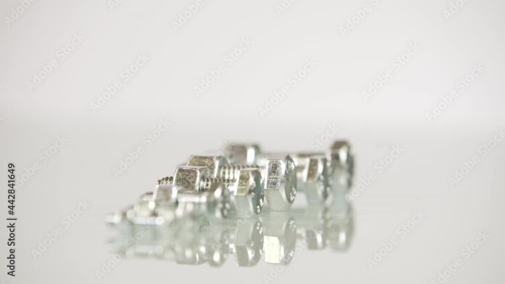 Steel screw with nut rotating on white background isolated Steel screw with nut rotating on white background isolated