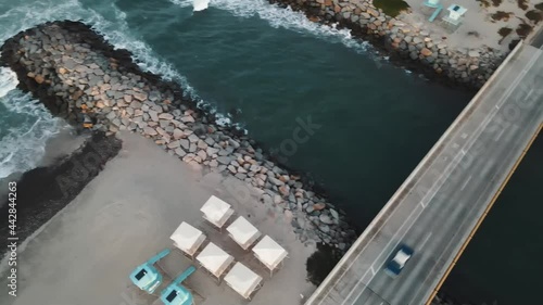 Classic car drives over an ocean inlet. Carlsbad CA