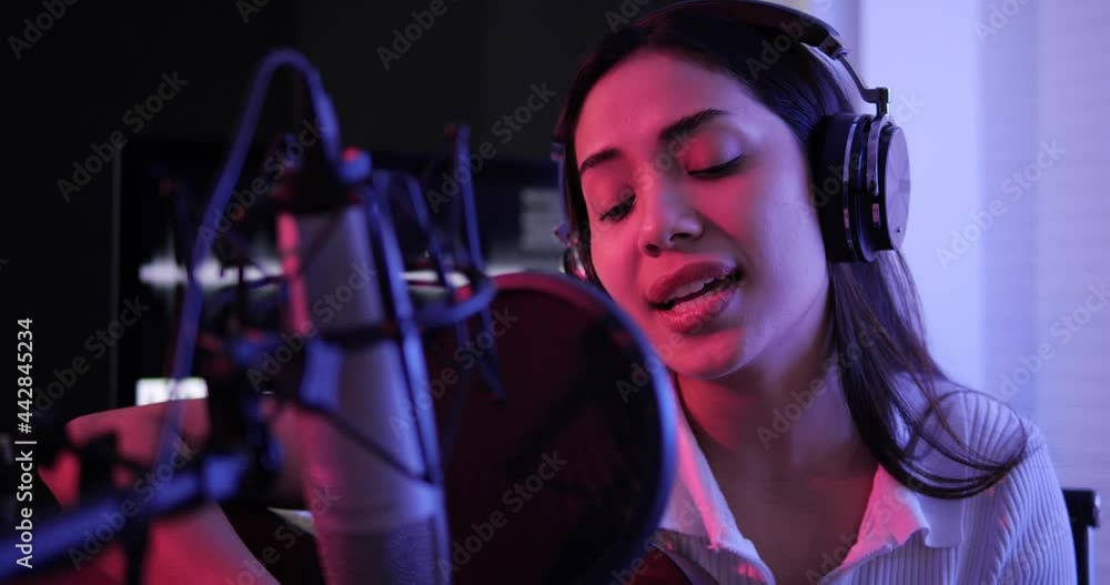 Female singer playing acoustic guitar and singing a song. Asian woman performing vocal artist singing in recording studio. Recording for her album. Female singer playing acoustic guitar and singing a song. Asian woman performing vocal artist singing in recording studio. Recording for her album.