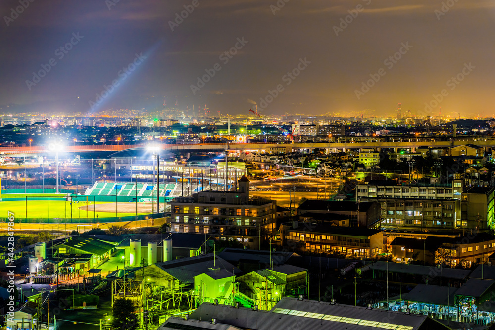 Fototapeta premium 街中にある工場と野球場の夜景。原池公園野球場