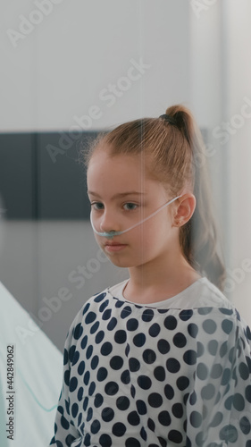 Pediatrician woman doctor listening patient lungs using medical stethoscope during recovery examination in hospital ward. Hospitalized sick girl recovering after medication surgery photo