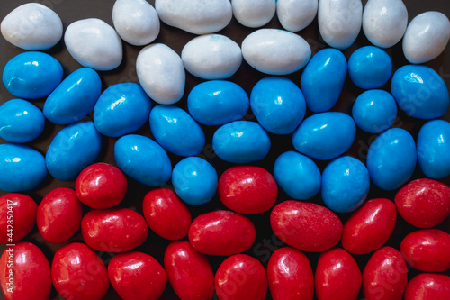 The flag of Russia is red blue and white made of colored sweet round chocolates peanuts in chocolate