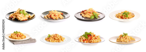 Plates with tasty pasta, tomatoes and feta cheese on white background
