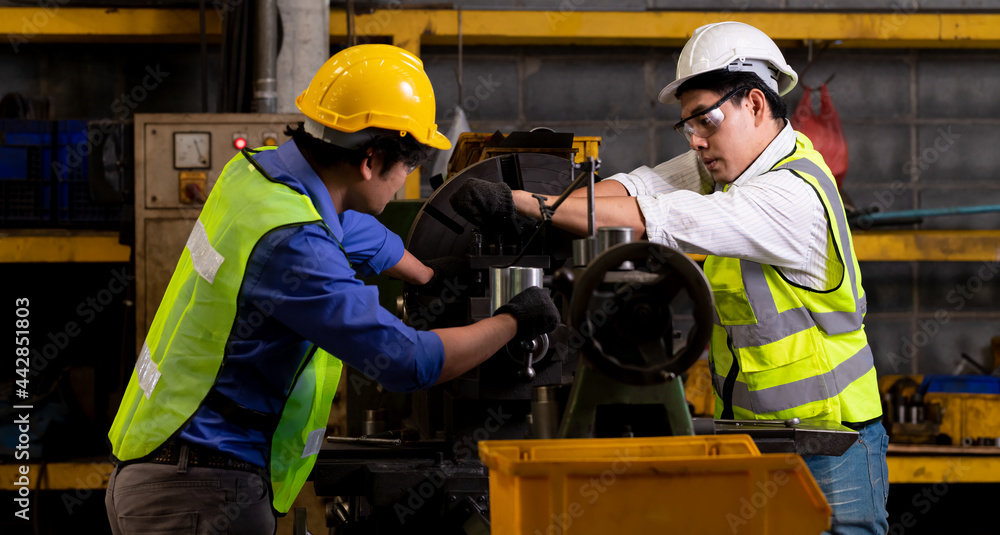 The Industry engineering wearing safety uniform control operating lathe grinding machine working in industry factory. The Industry engineering wearing safety uniform control operating lathe grinding machine working in industry factory.