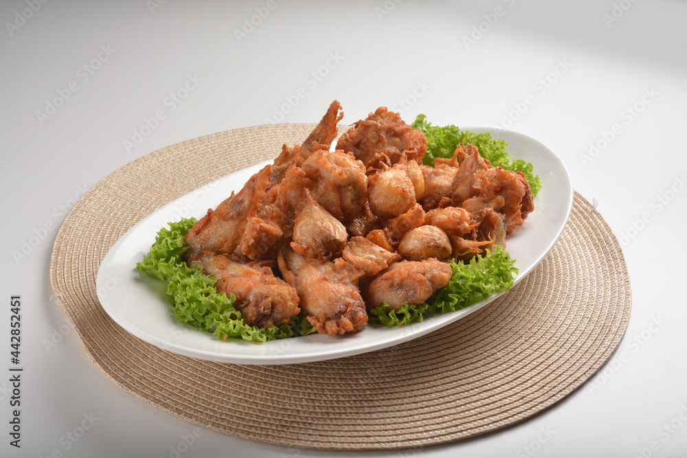 deep fried crispy chicken wing / pork rib with garlic in plate on white table asian cafe restaurant halal menu deep fried crispy chicken wing / pork rib with garlic in plate on white table asian cafe restaurant halal menu