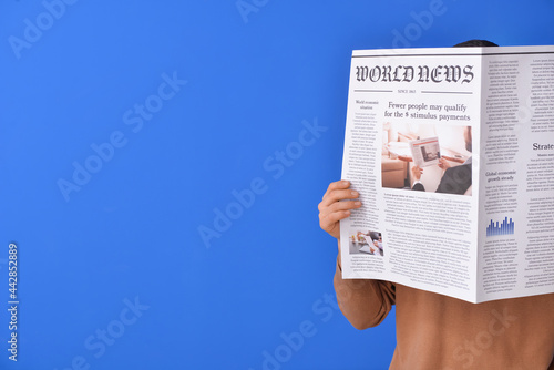 Young man reading newspaper...
