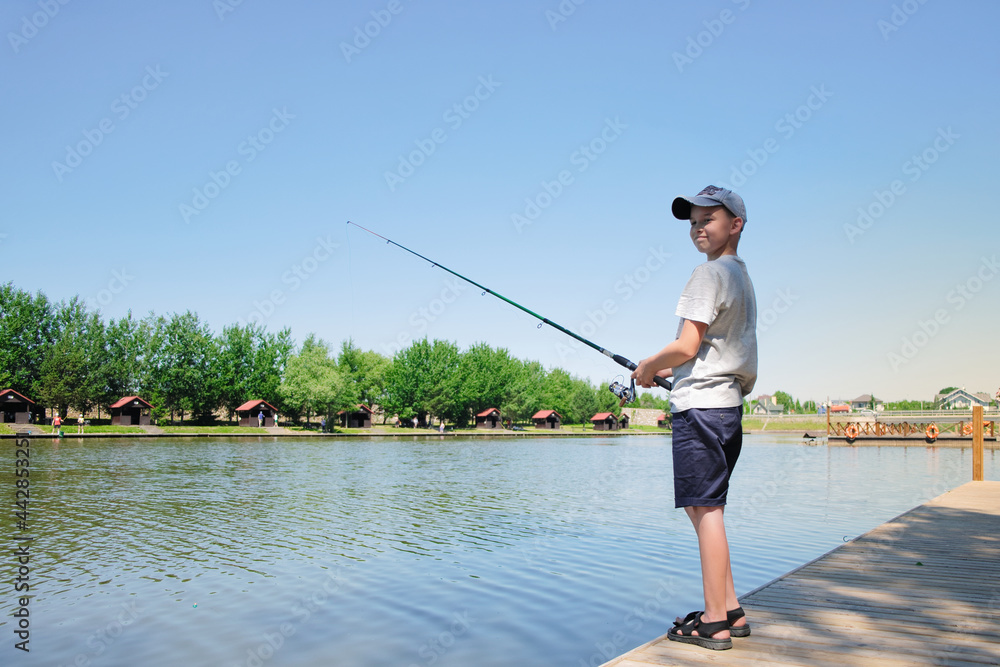 Young boy enjoys fishing at summer sunny day Young boy enjoys fishing at summer sunny day