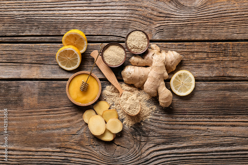 Composition with ginger powder, honey and lemon on wooden table