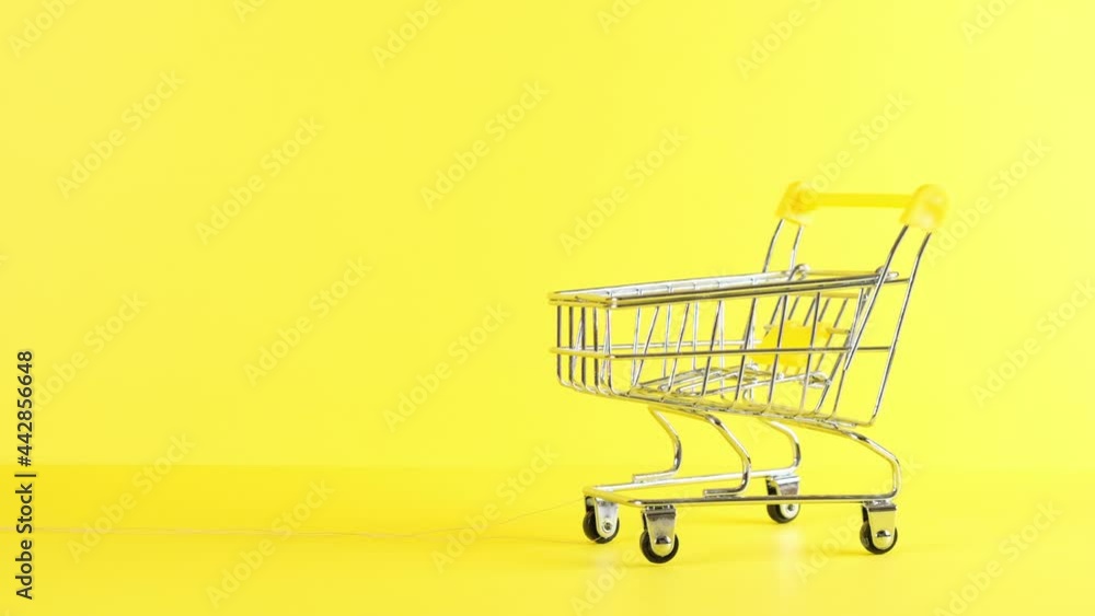 empty Shopping cart on a yellow background, closeup. Black Friday Shopping and Discount Concept empty Shopping cart on a yellow background, closeup. Black Friday Shopping and Discount Concept