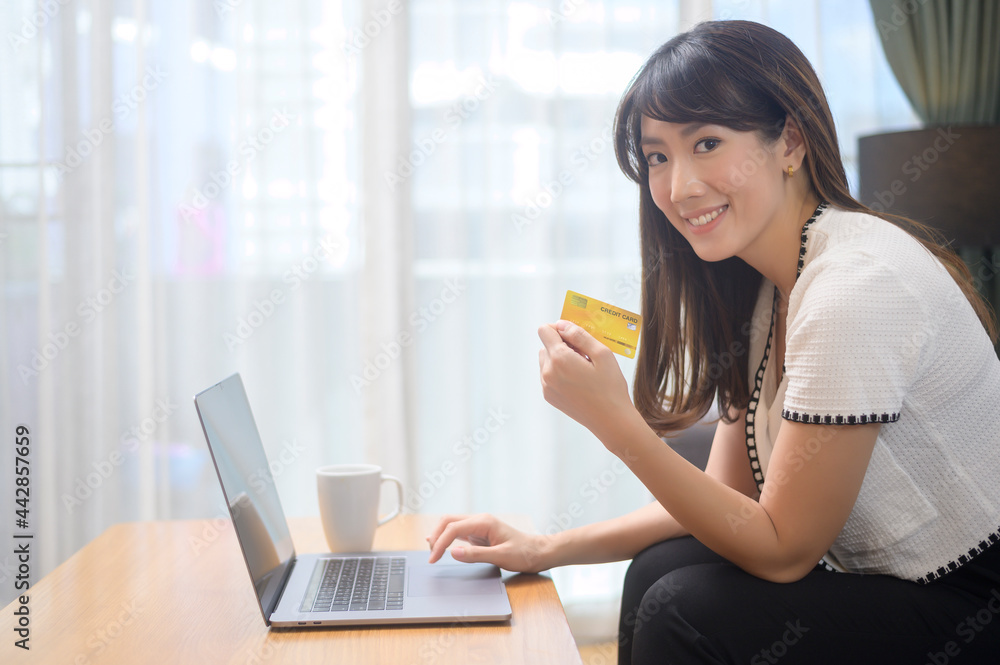 Young beautiful woman is using credit card for online shopping on internet website at home, e-commerce concept Young beautiful woman is using credit card for online shopping on internet website at home, e-commerce concept
