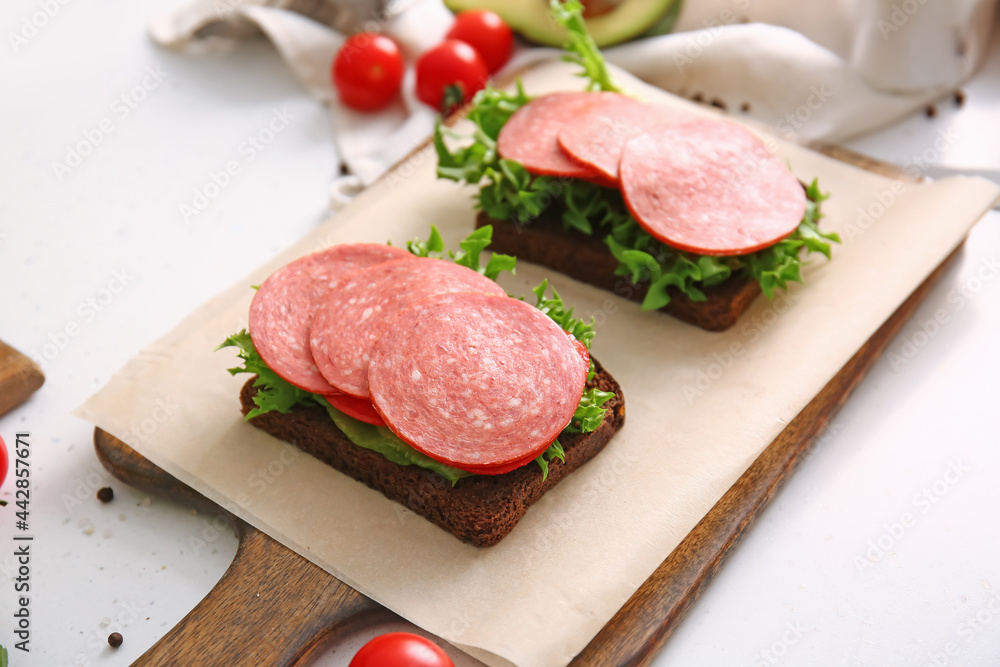 Preparing of tasty sandwiches on light background Preparing of tasty sandwiches on light background