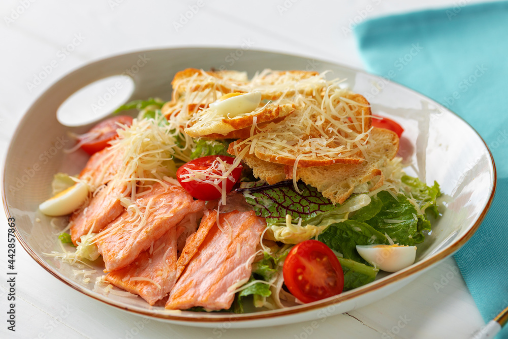 Caesar salad with grilled chicken on white wooden background Caesar salad with grilled chicken on white wooden background