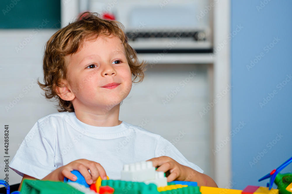 Child from elementary school. Toddler playing with building blocks toys at kindergarten. Child from elementary school. Toddler playing with building blocks toys at kindergarten.