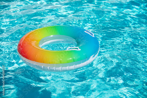 Summer water background. Inflatable ring in blue swimming pool.