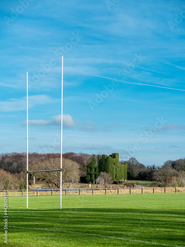 Tall goal posts for Irish National sports hurling, rugby, camogie, gaelic football. Warm sunny day, blue cloudy sky, Nobody. Menlo castle in the background. Galway city, Ireland. Vertical image