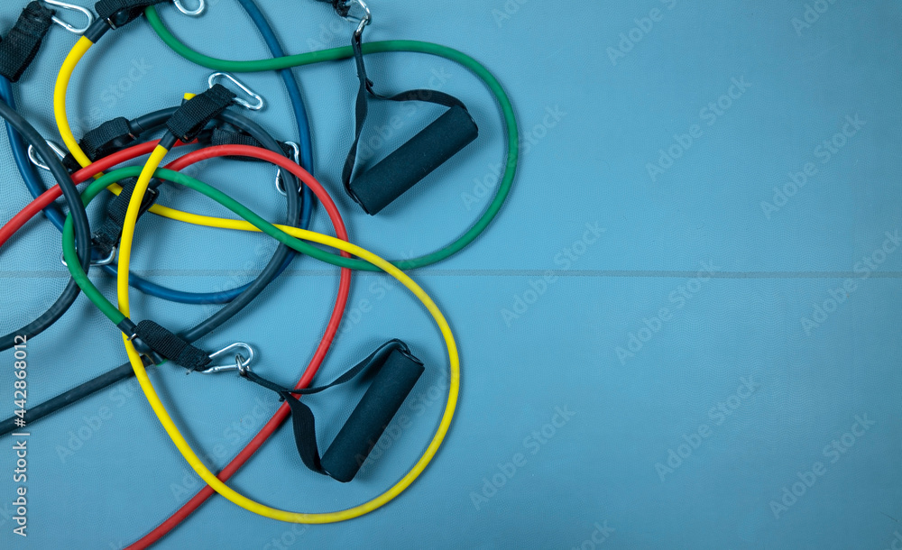Colorful elastic resistance bands on a blue fitness mat Colorful elastic resistance bands on a blue fitness mat