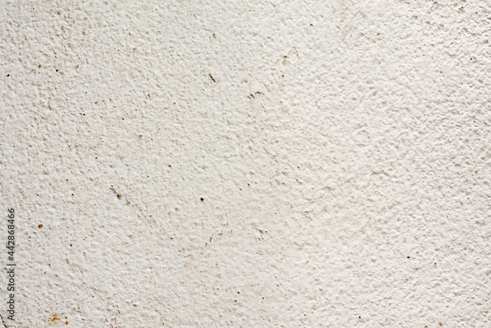 Rough surface of a concrete wall painted in greyish white, concrete wall background, blurred white background. Rough surface of a concrete wall painted in greyish white, concrete wall background, blurred white background.