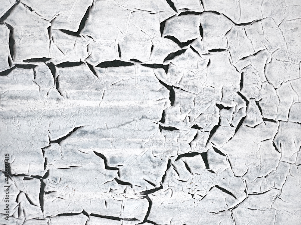Obraz premium The texture of the painted white wall is covered with large black cracks. Concept background, texture