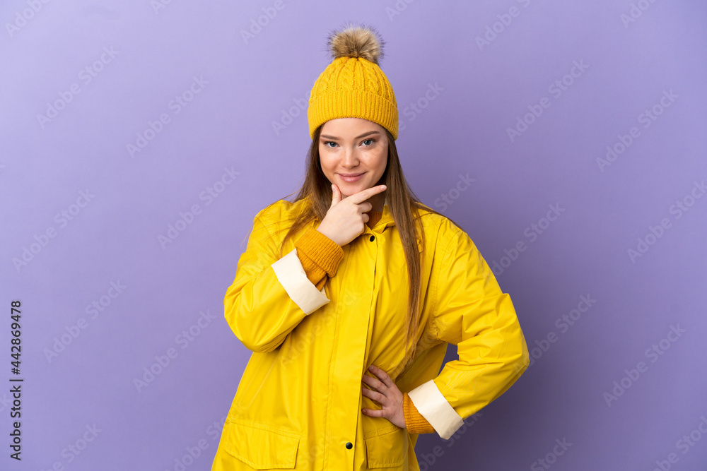 Teenager girl wearing a rainproof coat over isolated purple background thinking Teenager girl wearing a rainproof coat over isolated purple background thinking