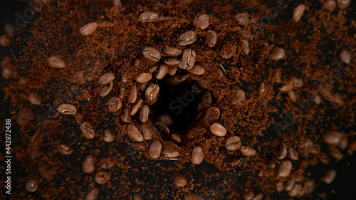 Rotating Coffee Beans in coffee grinder, Black Background.