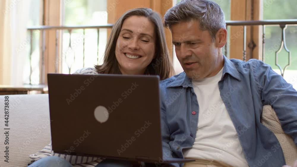 Tracking Shot Past Foreground Revealing Middle Aged Couple On Video Call Tracking Shot Past Foreground Revealing Middle Aged Couple On Video Call