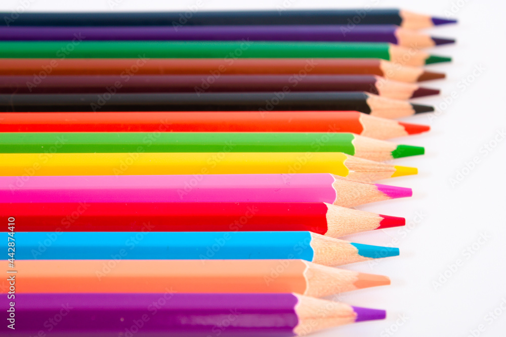 Coloured pencils in a row isolated on white background, selective focus Coloured pencils in a row isolated on white background, selective focus