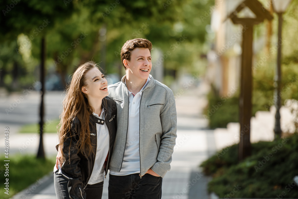 young happy beautiful couple laughing and hugging in the street. . young happy beautiful couple laughing and hugging in the street. .
