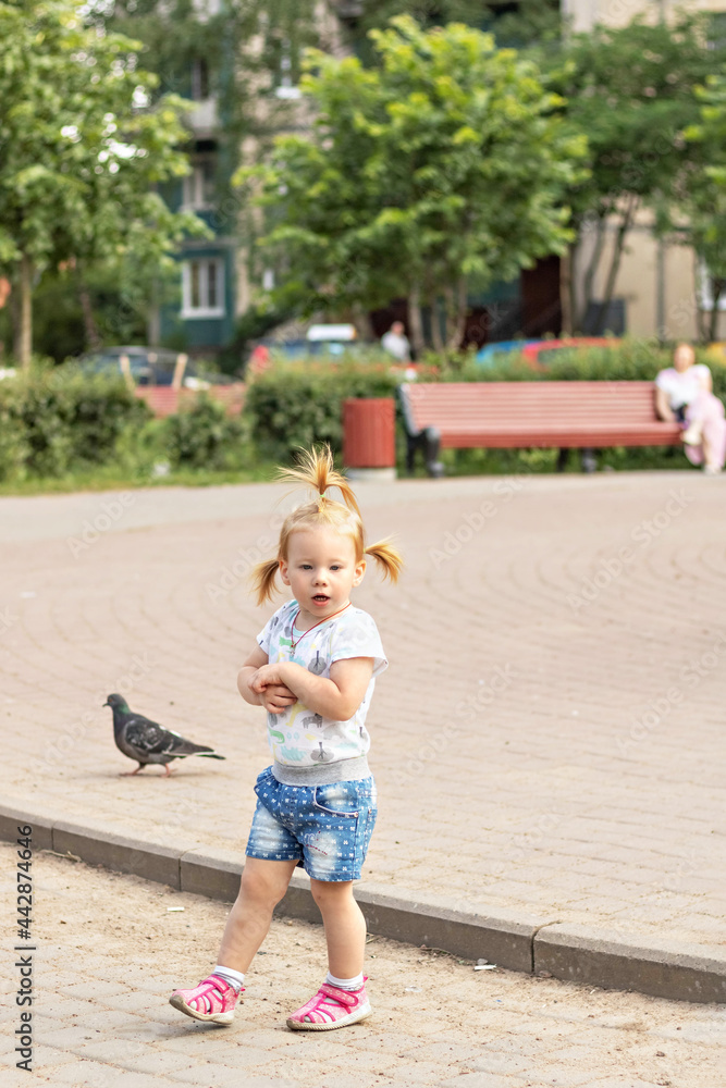 Little girl toddler runs after pigeons. Summertime Little girl toddler runs after pigeons. Summertime