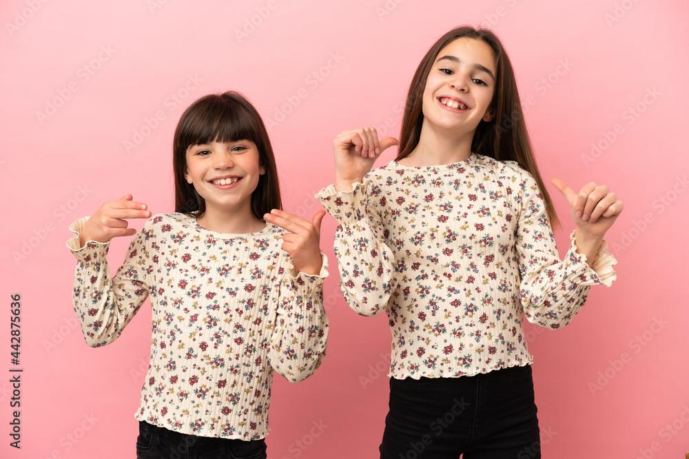 Little sisters girls isolated on pink background proud and self-satisfied in love yourself concept Little sisters girls isolated on pink background proud and self-satisfied in love yourself concept