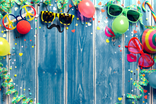 Party glasses and balloons on wooden background
