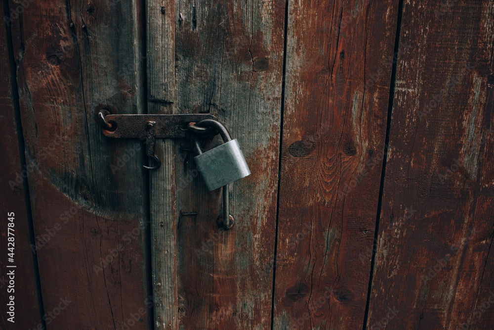 Metal padlock on old wooden gate, rustic rural wallpaper, wood texture on old door Metal padlock on old wooden gate, rustic rural wallpaper, wood texture on old door