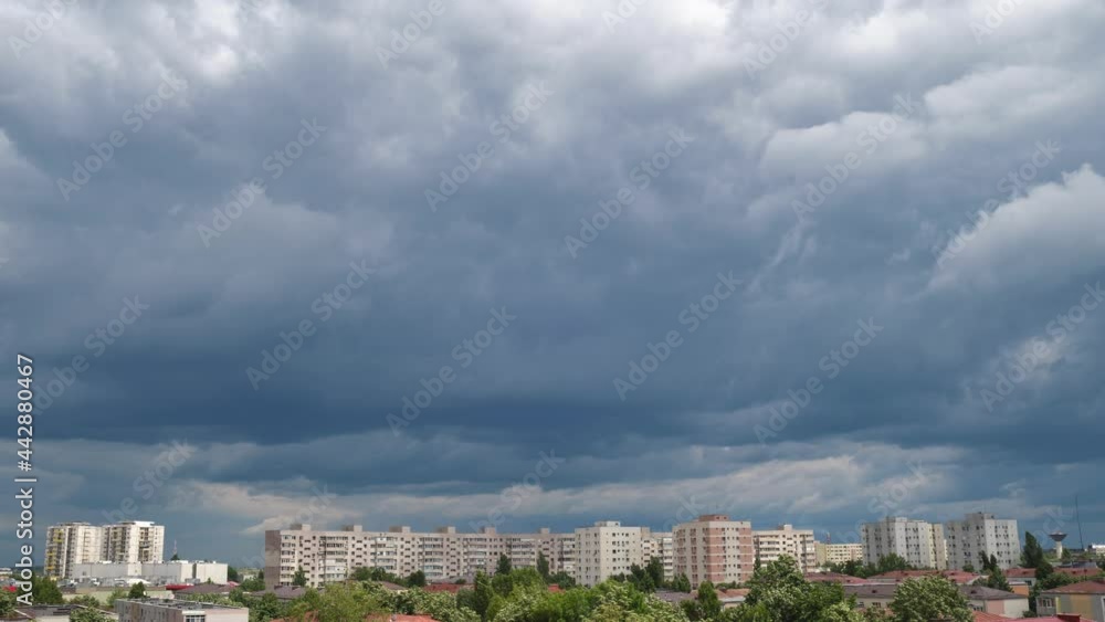 Dark Stratocumulus cloud layer, above urban buildings - tilt up. Stormy weather, ominous sky, time lapse. Dark Stratocumulus cloud layer, above urban buildings - tilt up. Stormy weather, ominous sky, time lapse.
