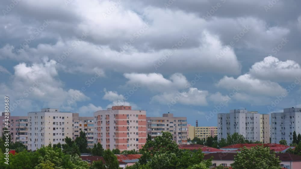 Timelapse of Cumulus clouds below gray dark stratus layer. Changing Summer weather in urban environment with apartment buildings. Timelapse of Cumulus clouds below gray dark stratus layer. Changing Summer weather in urban environment with apartment buildings.