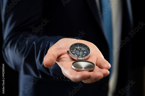 Businessman holding a navigation compass in his hand. Business planning and business navigation for recovery so that businessmen resume business growth amid the economic crisis