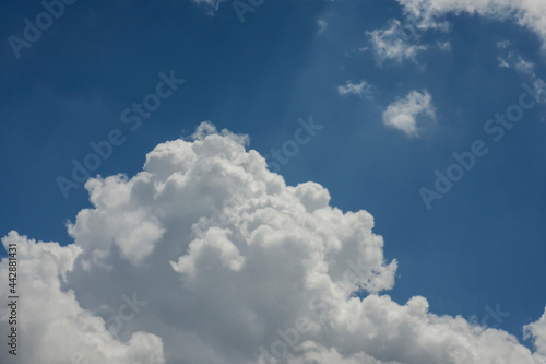 Blue sky and cottony clouds on a partly cloudy and bright day. Cumulus clouds. copy space.
