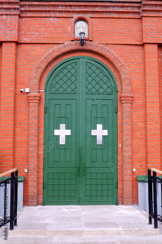 Closed entrance doors to a red brick church