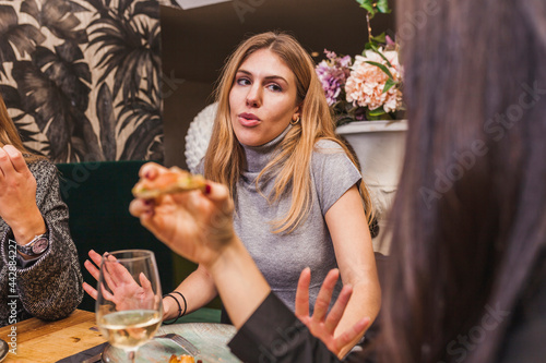 Group of friends eating at a dinner party at restaurant