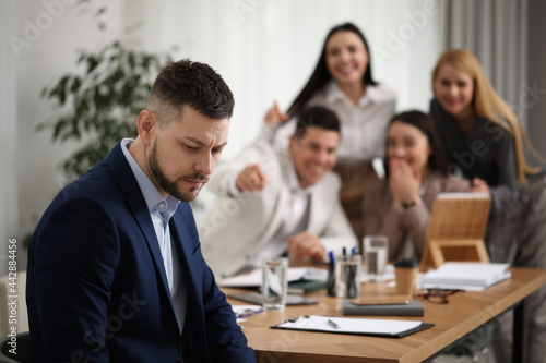 Coworkers bullying their colleague in office, space for text