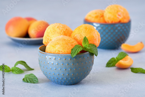 Homemade apricot or peach ice cream , sorbet in bowl with mint leaves. Closeup photo