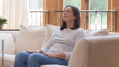 Tracking Shot Orbiting Around Middle Aged Woman Meditating On Sofa