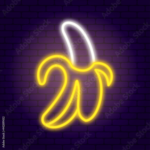 Neon banana on dark brick wall background