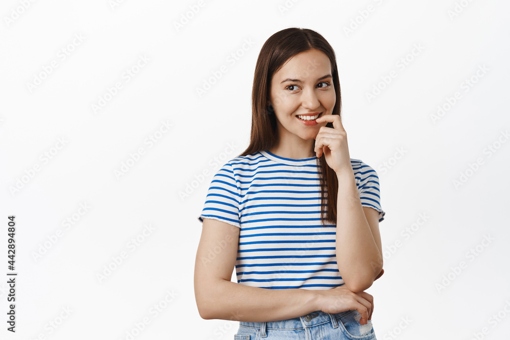 Image of young 20s woman thinking, smiling cunning and looking left at sale, having an idea, ponder smth interesting, standing in t-shirt against white background, has plan Image of young 20s woman thinking, smiling cunning and looking left at sale, having an idea, ponder smth interesting, standing in t-shirt against white background, has plan