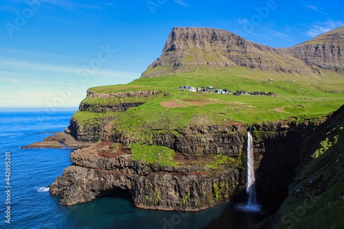 Mulafossur Waterfall with the village of Gasadalur on Faroe Islands photo
