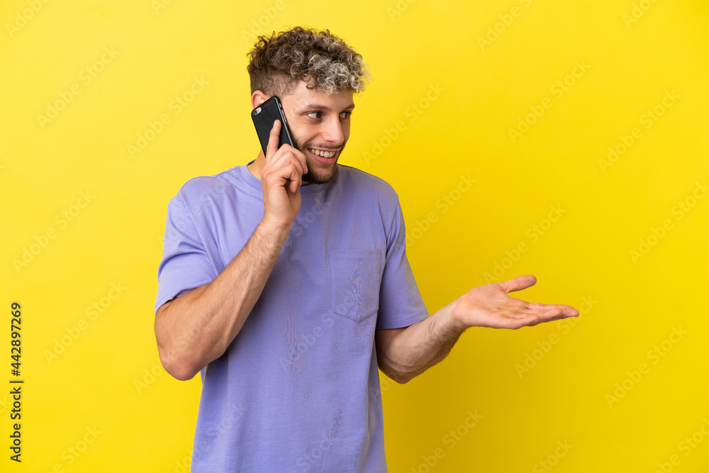 Young caucasian man using mobile phone isolated on yellow background with surprise expression while looking side Young caucasian man using mobile phone isolated on yellow background with surprise expression while looking side