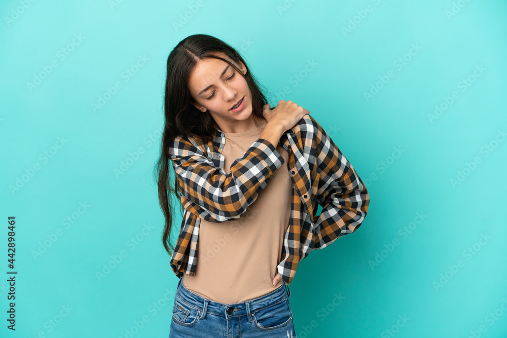 Young French woman isolated on blue background suffering from pain in shoulder for having made an effort Young French woman isolated on blue background suffering from pain in shoulder for having made an effort