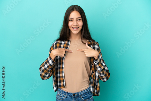 Young French woman isolated on blue background with surprise facial expression